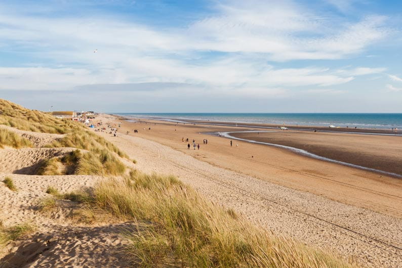 Dunes and sand stretching out into the distance along Camber Sands beach