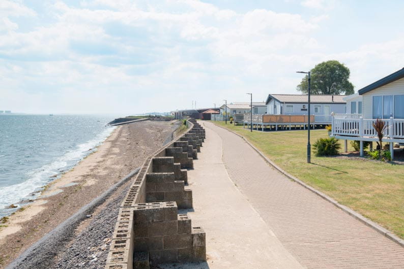 Caravans overlooking the sea at Coopers Beach Holiday Park on Mersea Island in Essex