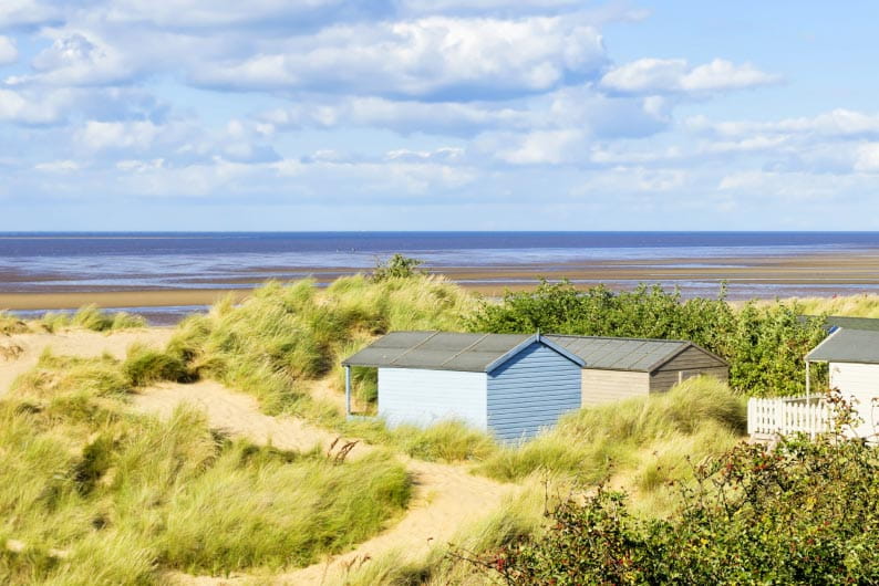 Beach huts nestled in the dunes overlooking the beach at Hunstanton, Norfolk