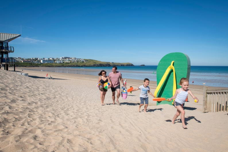 A family walking along Fistral Beach in Cornwall