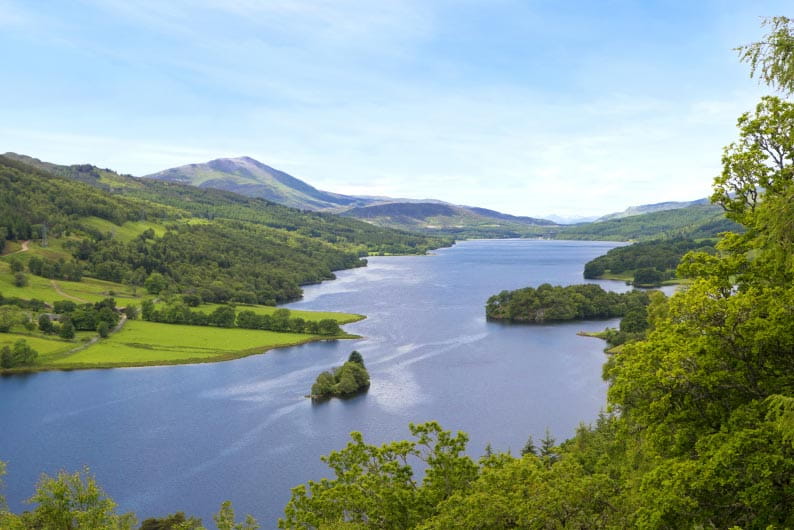 The Queens View viewpoint overlooking Loch Tummel, surrounded by green rolling hills in the Scottish Highlands