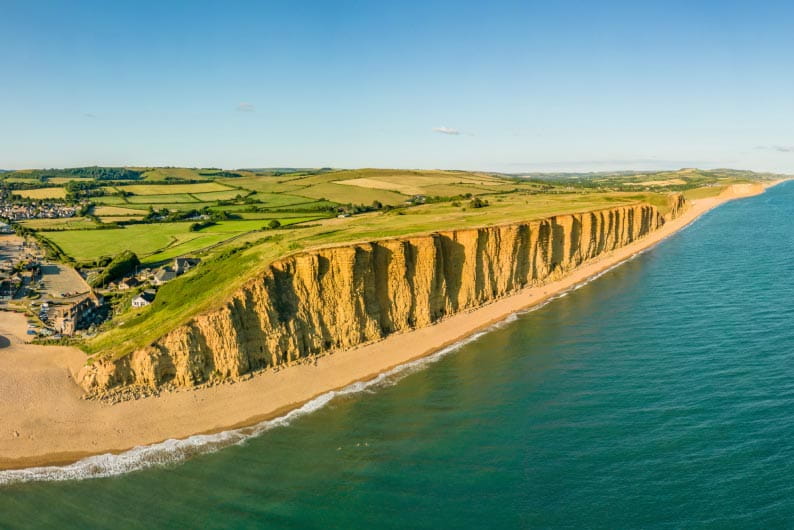 The golden sandstone cliffs lining West Bay's beach in Dorset