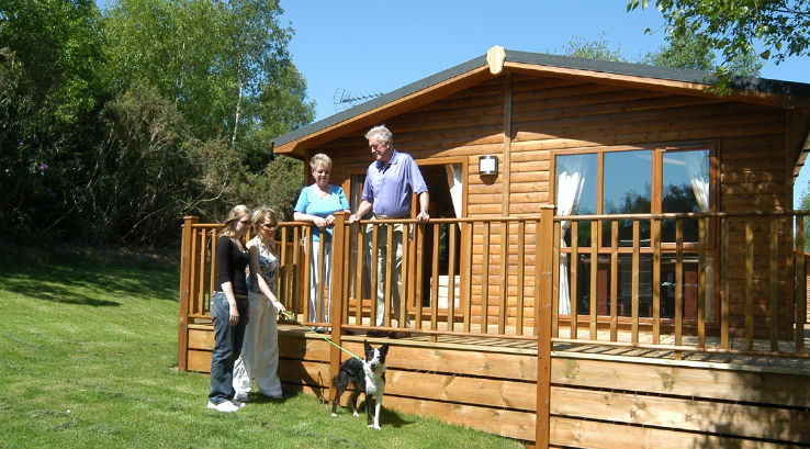 Family and Dog Beside Cabin