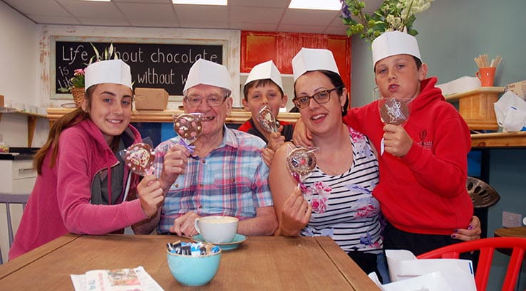 Family in chef hats holding lollies