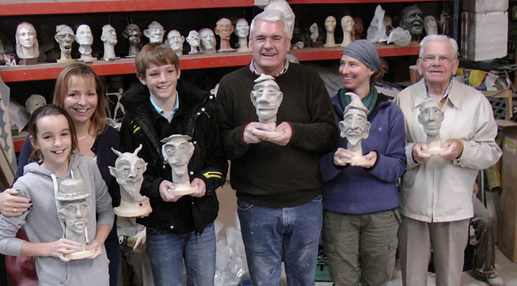 Family holding up sculptures