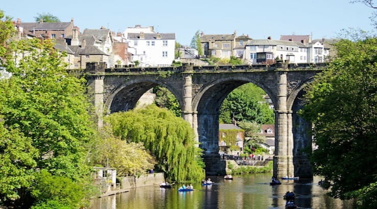 Boats on river beneath high bridge