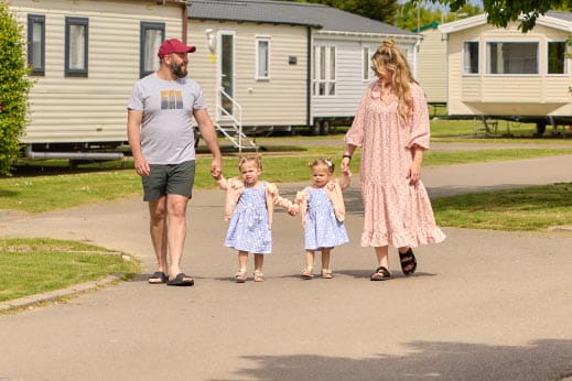 Family walking hand in hand through Parkdean Resorts