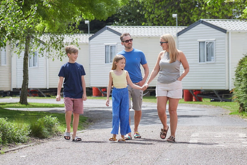 Family walking hand in hand through Parkdean Resorts