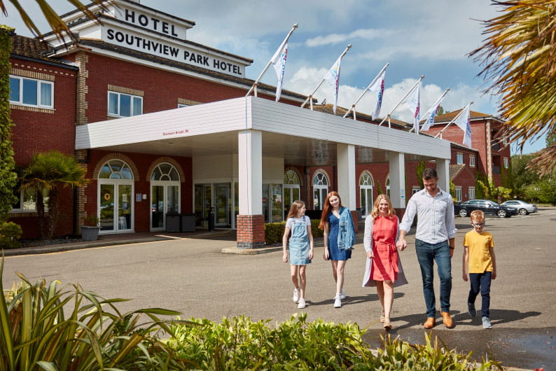 Family walking outside hotel at Parkdean Resorts