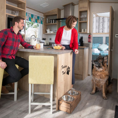 Couple inside caravan looking at their pet dog