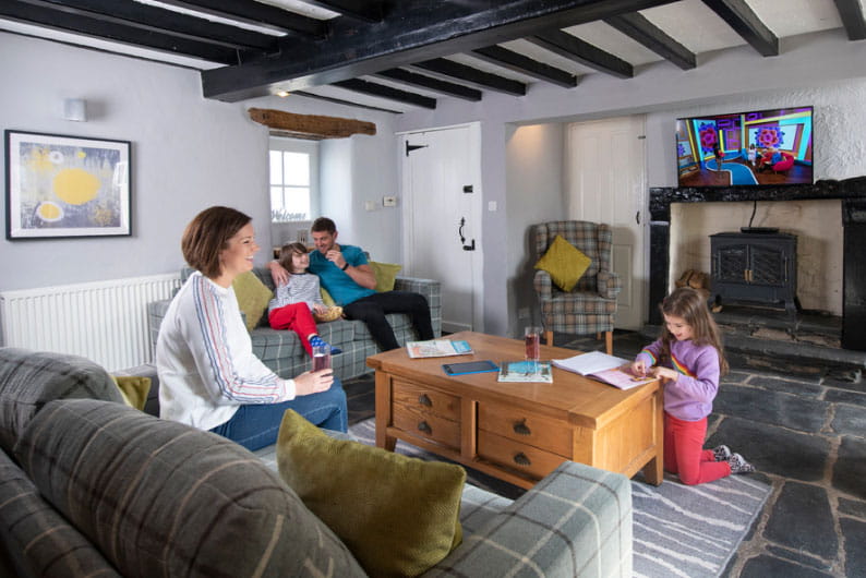 A family gathered around in the living room of their holiday bungalow