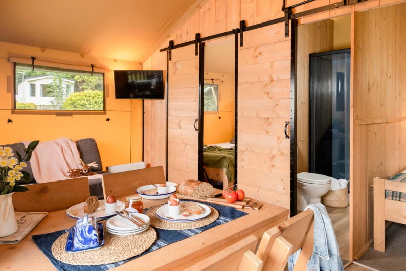 Inside the living and dining area of a Parkdean Resorts safari glamping tent