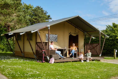 A family sat outside their glamping tent at Holywell Bay Holiday Park