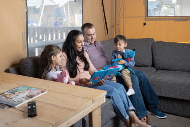 A family in the living room of their glamping tent at Lower Hyde Holiday Park