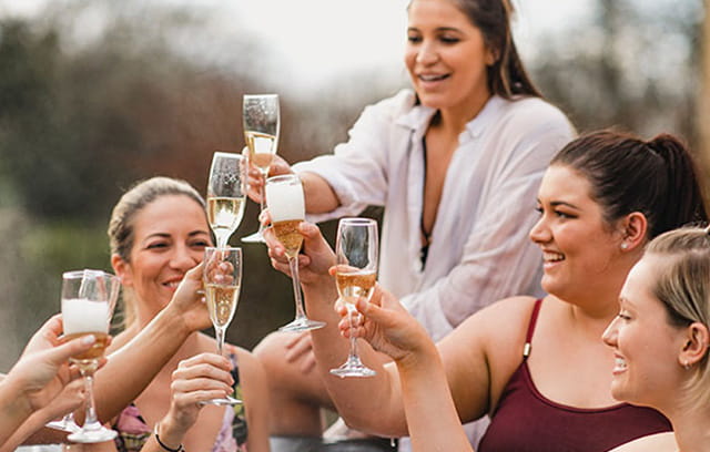 A group of female friends enjoying champagne in their hot tub