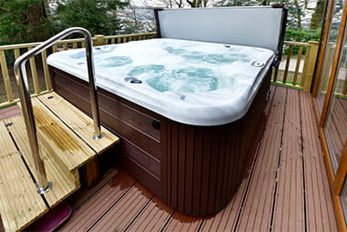 A hot tub on the veranda of a holiday lodge