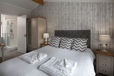 A stylish double bedroom in a hot tub lodge at Parkdean Resorts