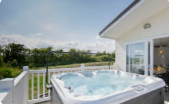 A holiday lodge with a hot tub bubbling away on its veranda