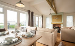A light and spacious open plan living and dining area inside a holiday lodge