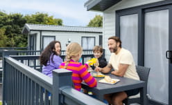 A family enjoying a meal on the veranda of their caravan