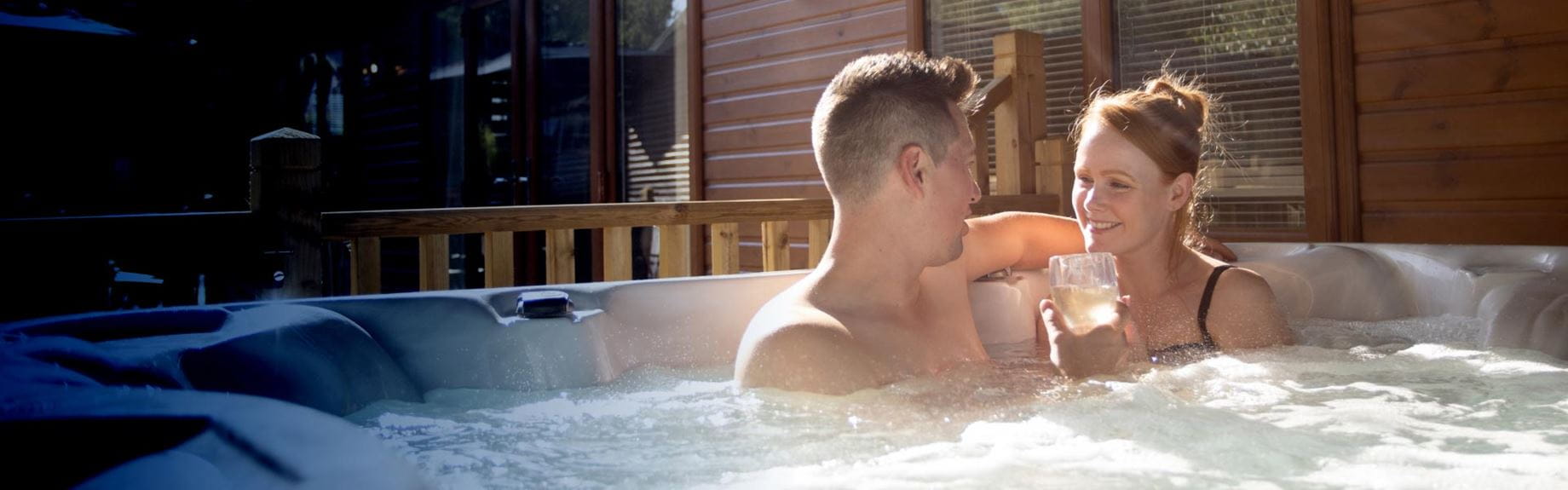 Couple drinking wine in a hot tub