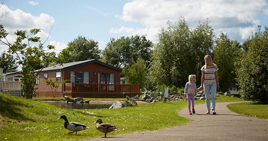 A family walking past a lodge at Southview Holiday Park in Skegness