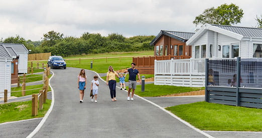 A family walking past holiday lodges on the Isle of Wight