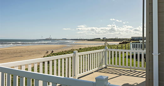 A lodge veranda overlooking a Northumberland beach