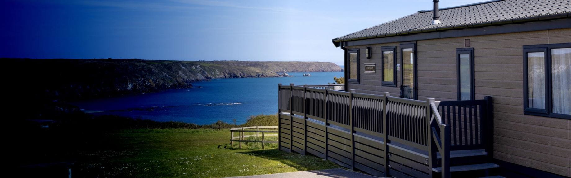 Exterior shot of a lodge with a veranda at Parkdean Resorts
