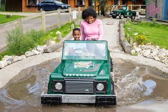 Little boy and mum driving off ranger car at Parkdean Resorts