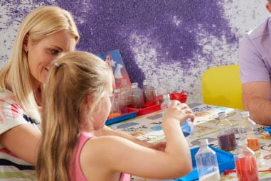 child and mother making crazy sand art