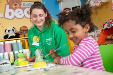 child and Parkdean Resorts employee creating crafts with paint