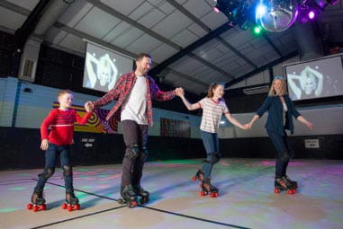 a family in skates on a roller rink