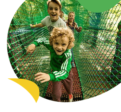 Children running through a tree top adventure course