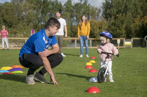 Parkdean Resorts staff with child on a bike