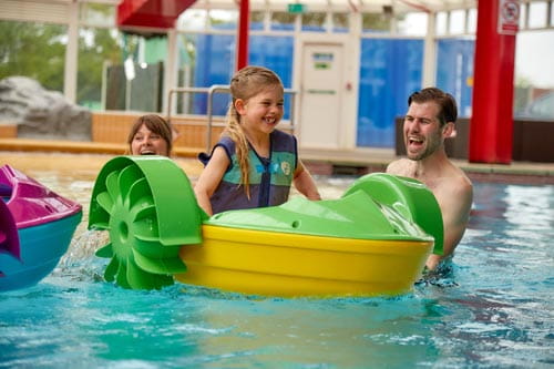 Little girl on plastic boat in swimming pool