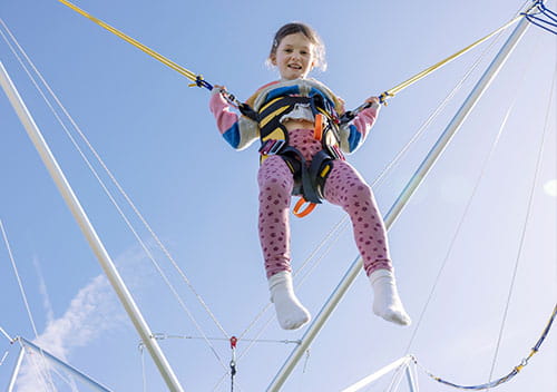 Little girl in the air on the bungee trampoline