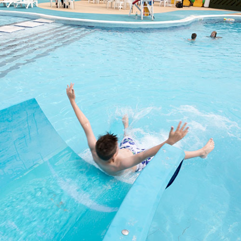 Boy sliding into the outdoor pool at Barmston Beach Holiday Park