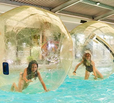 Girls taking part in the water walker activity in the indoor swimming pool