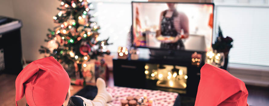 A couple watching a Christmas film on their TV