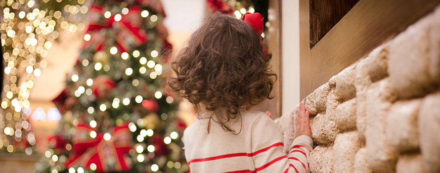 A child staring at a Christmas tree