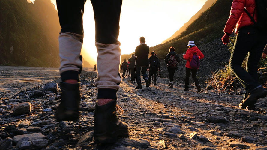 Walkers on a trail at sunrise