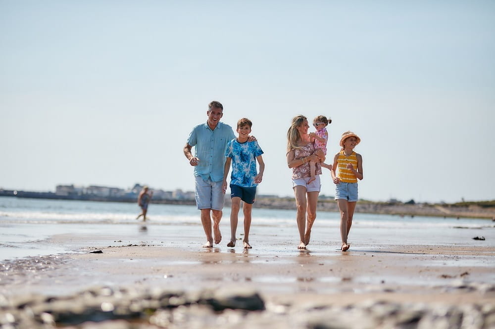 A family walking along the beach in Wales