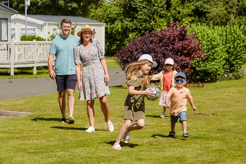 Family playing tag on the grass