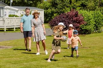 Family playing tag on the grass