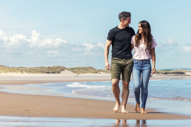 Couple walking lovingly on the sand