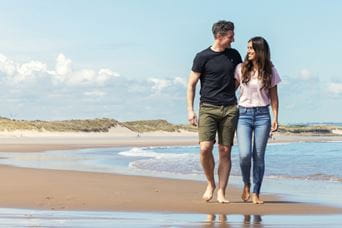 Couple walking lovingly on the sand