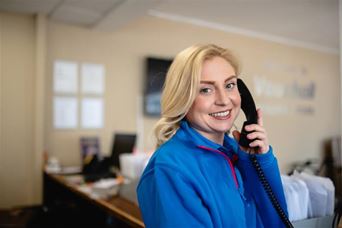 Blonde lady smiling on the telephone at Parkdean Resorts