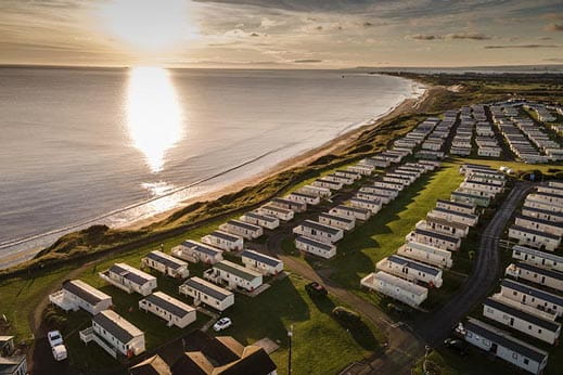 Caravans on the cliff edge with sunset in the background