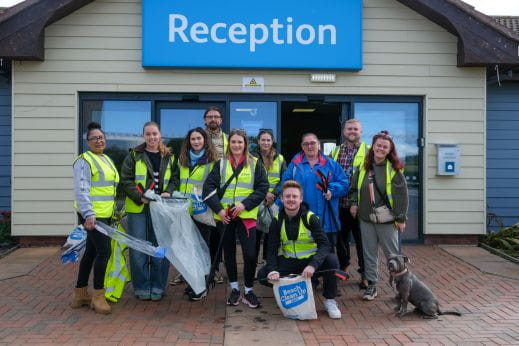 Group of people outside reception with litter picking equipment